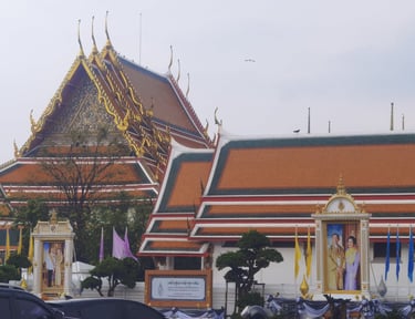 Wat Suthat Thepwararam temple in Bangkok, Thailand with traditional tiered roofs and royal portraits.