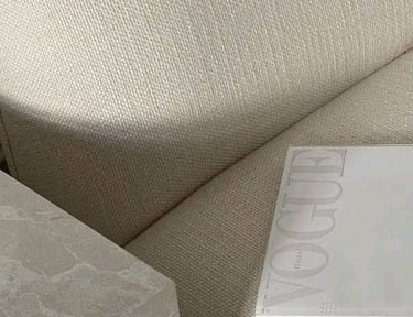 Soft neutral-toned fabric with a Vogue magazine, representing brand aesthetics and style.