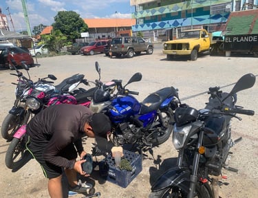 Mecánico realizando mantenimiento a motocicletas Empire Keeway en un estacionamiento al aire libre