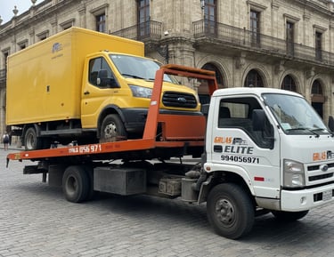 Camión grúa de plataforma transportando un camion de carga en una avenida urbana de Lima