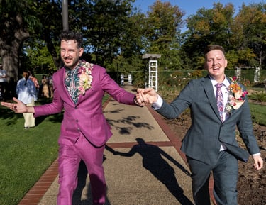 Two grooms dacing, smiling post wedding ceremony, captured by Canberra photographer