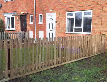 New timber picket fence installed in a front garden of a brick terraced house.