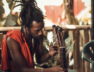 a man with dreadlocks sitting on a chair