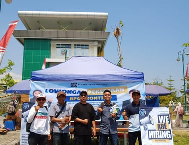 a group of people standing around a table with a sign