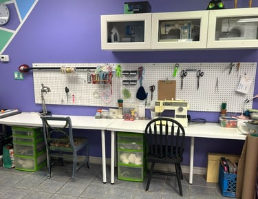 two desks with chairs, and a selection of sewing supplies and notions