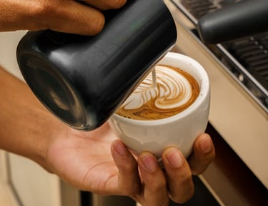 a person is pouring coffee into a cup 