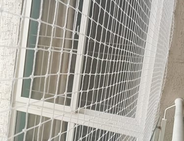 A smiling family enjoying their balcony, protected by a safety net.