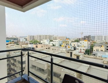 Technician carefully installing a safety net on a balcony, ensuring perfect fit and safety.
