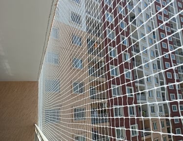 Wide view of a modern apartment balcony fully protected with a neatly fitted pigeon net.