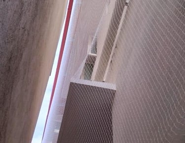 Wide shot of a residential building with neatly installed duct area nets preventing bird entry.