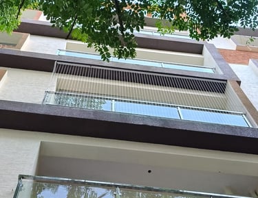 Technician from Arjilli Enterprises carefully installing invisible grills on a window in mylapore.