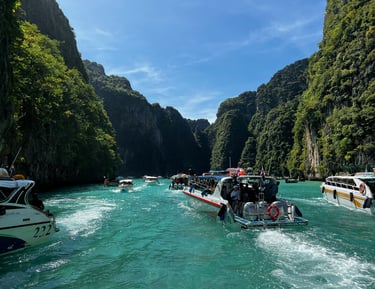 Speed boats and tourists exploring islands in Krabi, Thailand including Chicken Island and Poda Island
