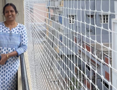 An elderly person relaxing on a balcony protected by a safety net, with pigeons perched outside.