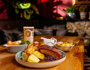 Roast dinner on a table in the snug area with a pint of beer