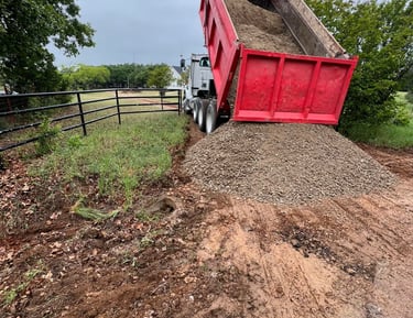 dumping gravel on dirt road