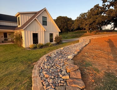 a stone wall with a stone path leading to a house