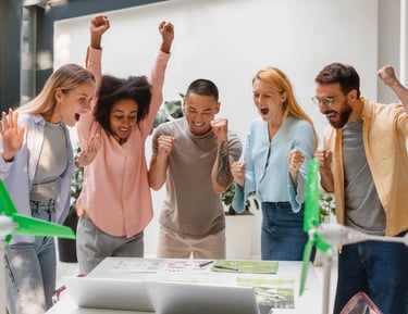 Jovens lĂderes celebrando resultado de trabalho colaborativo