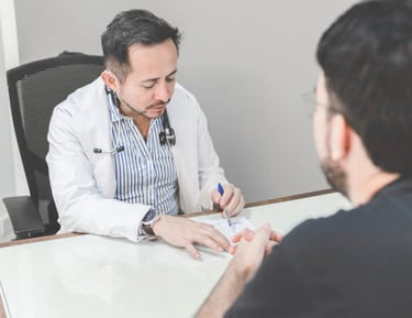 Médico atendiendo a un paciente en consulta, ofreciendo servicios médicos para empresas.
