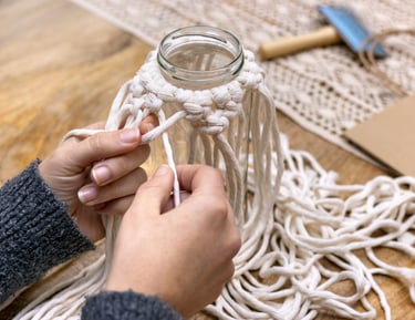 manos tejiendo joyas de macramé