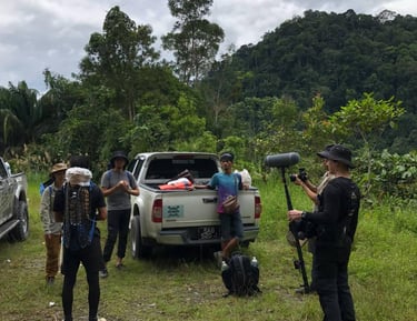 a group of people standing around a truck during documentary shooting
