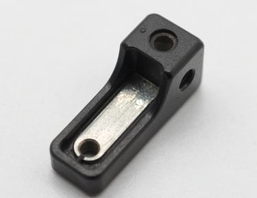 An engineer inspecting OEM parts with a caliper in a bright workshop.