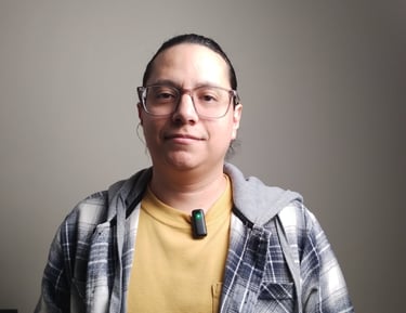 un hombre llamado jose Francisco con camisa de cuadros y un microfono