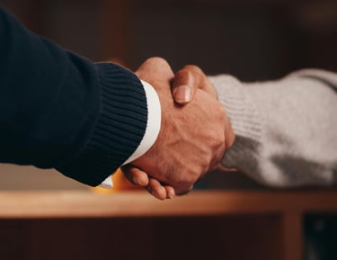 Professional close-up of a firm business handshake between two people closing a deal.