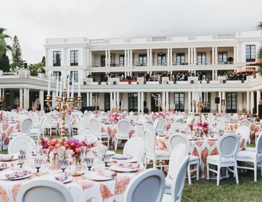 Large-scale garden banquet with illuminated villa backdrop