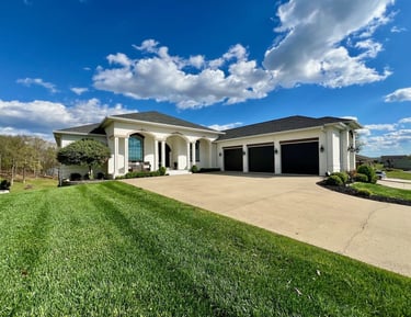 An large white house with 3 car garage on a large lot