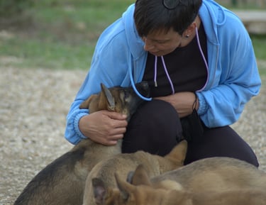 a woman in a blue jacket is holding a dog