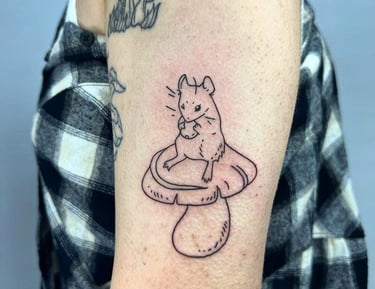 a mouse sitting on top of a mushroom made at Inari Tattoo