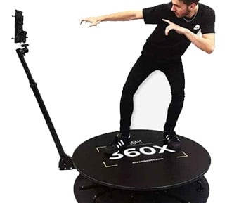 a man standing on a 360 photo booth with a camera