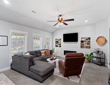 a living room with a couch and a ceiling fan