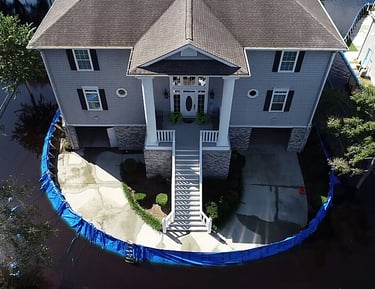 Coastal home protected by modular temporary flood barrier panels during high water