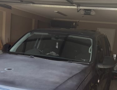 A black ute in a garage showing sun-damaged paint on the hood.