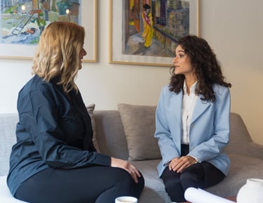 two women sitting on a couch in a living room