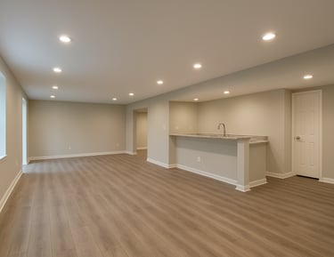 Wide interior shot of a finished basement in a Delaware home — recessed lighting, painted drywall, LVP flooring, a small bar area to one side, daylight-balanced artificial light, no people