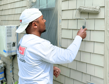 a man painting a house; exterior painting