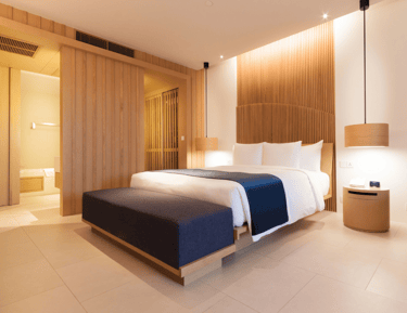 Quarto com cama arrumada, iluminação inteligente e cortina motorizada