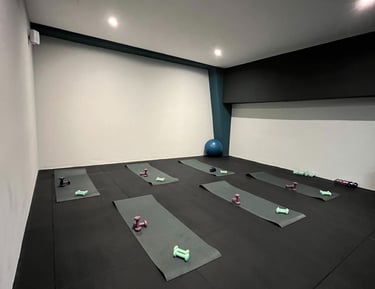 Sala fitness della palestra Move 2 Grow a Milano con tappetini, manubri e attrezzature per allenamenti di gruppo.
