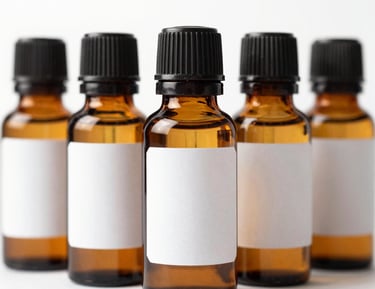 Hands carefully blending essential oils into a custom bottle surrounded by natural ingredients.