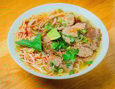 a bowl of noodles with meat and vegetables