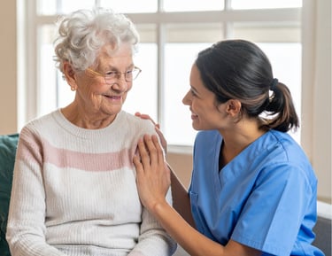 A female caregiver smiling with a female patient
