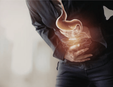 Person clutching abdomen with glowing stomach and intestines illustration showing digestive pain