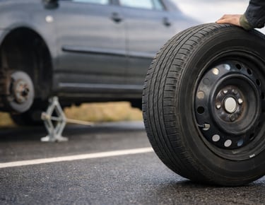 estepe de carro sendo usado na troca de pneu na estrada
