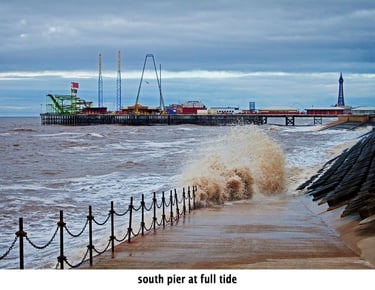 blackpool south pier at full tide with splashing waves in the foreground