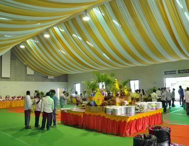 a large room with a lot of people standing around a table