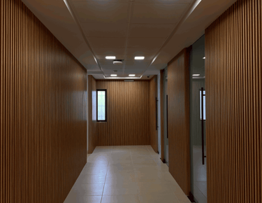 Pasillo con acabado de madera en muros y plafón con luminarias LED | KARÄNA