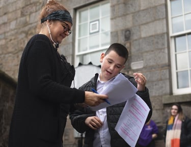 Production manager at a production company with a woman and a boy in front of a building