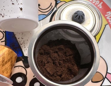Ground coffee inside a reusable stainless steel mesh filter pod for coffee makers.
